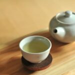 white ceramic teacup on brown wooden table green tea