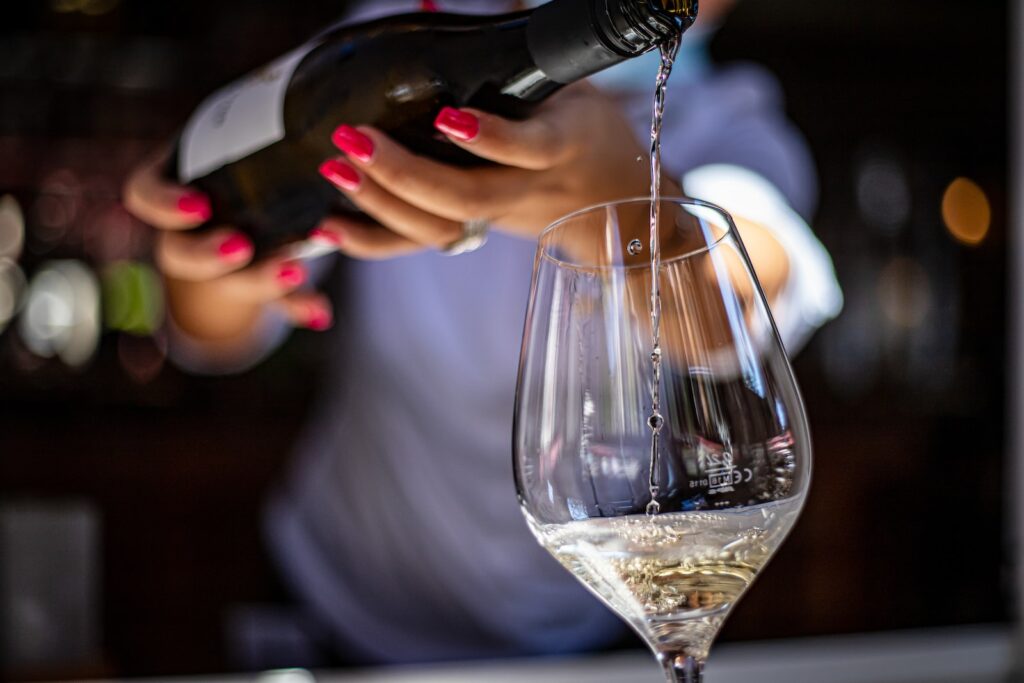 mulher servindo uma taça de vinho branco