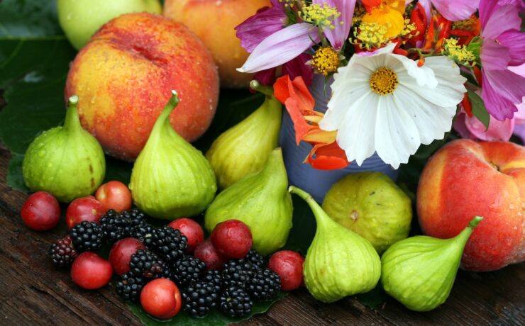 une table en bois garnie de nombreux fruits et fleurs