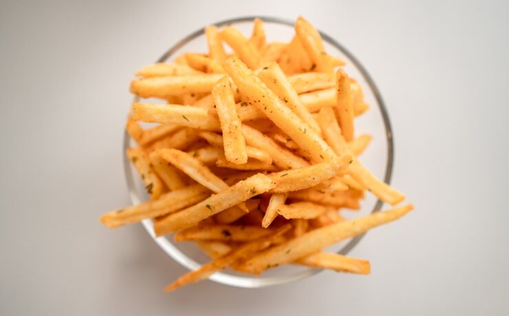 batatas fritas em um pote de vidro sobre superfície branca