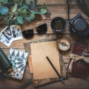 foto de vários objetos relacionados à viagens, sobre mesa de madeira