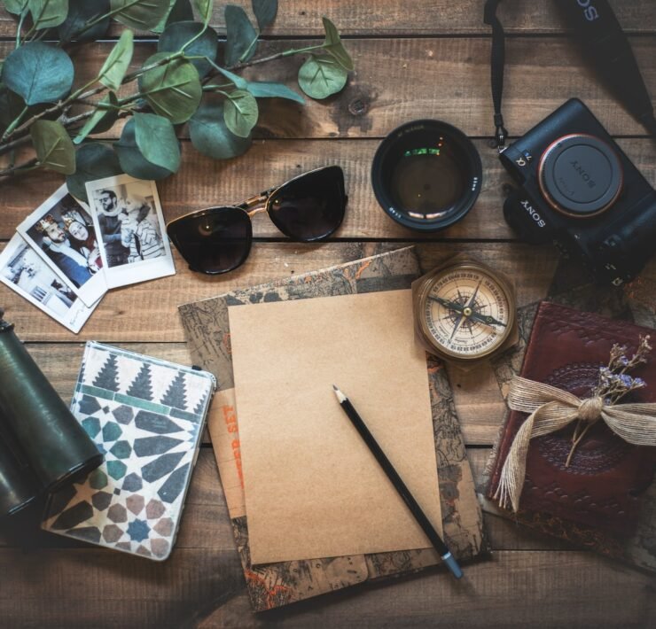 foto de vários objetos relacionados à viagens, sobre mesa de madeira