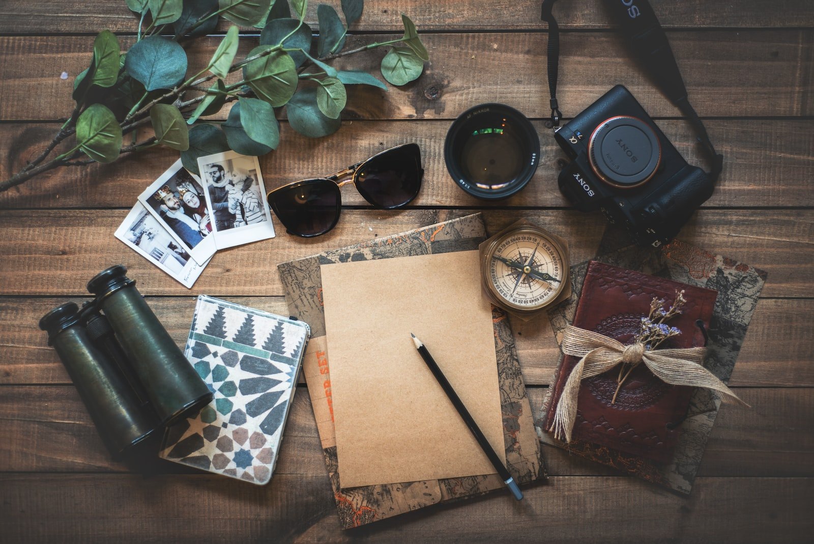 foto de vários objetos relacionados à viagens, sobre mesa de madeira