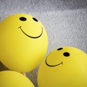 emoji amarelo sorridente sobre tecido cinza