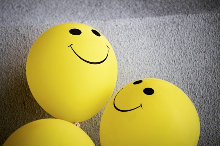 emoji amarelo sorridente sobre tecido cinza