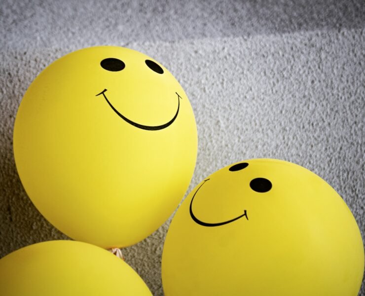 emoji amarelo sorridente sobre tecido cinza