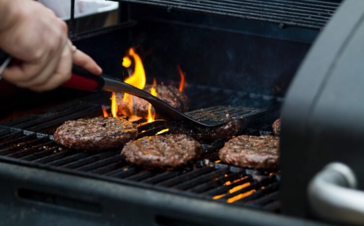 persona che griglia polpette di hamburger cucinare