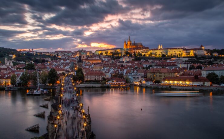 city skyline near body of water during night time prague italy