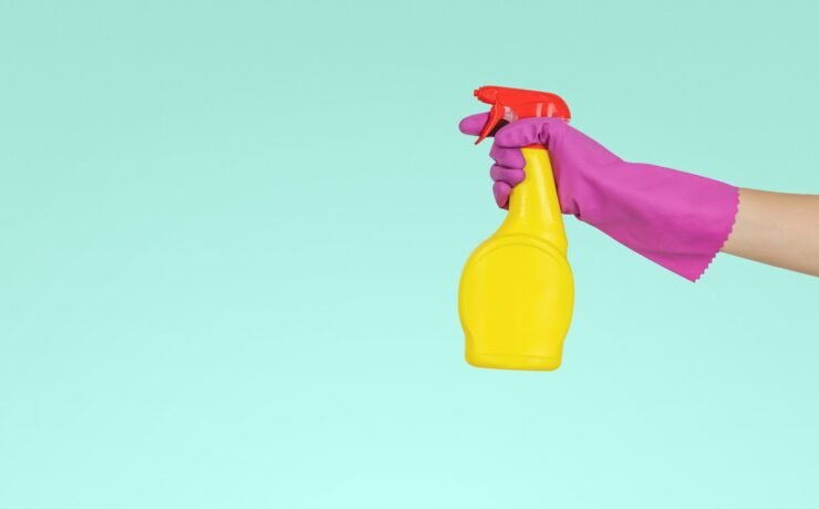 pessoa segurando frasco de spray de plástico amarelo