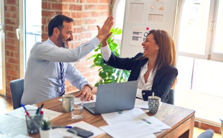 man in white dress shirt sitting beside woman in black long sleeve shirt enthusiasm colleagues