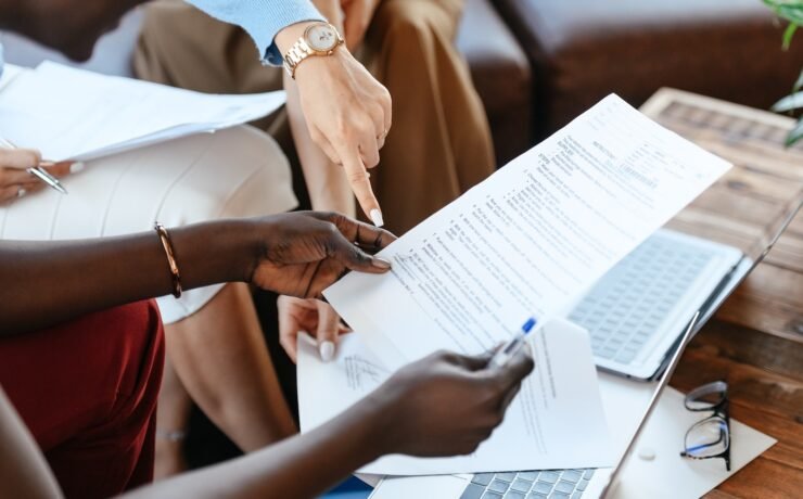 Multiethnic businesswomen checking information in documents office colleagues