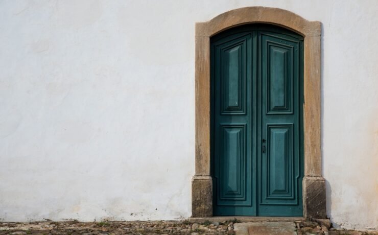 porta estilo barroco azul em uma parede branca