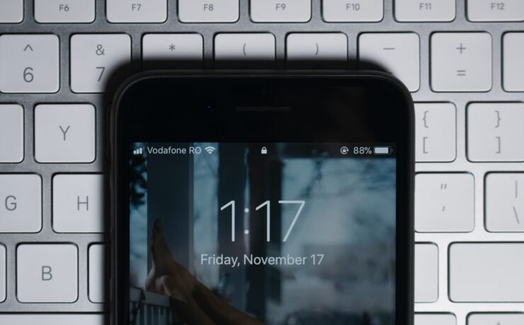 black iPhone on gray computer keyboard