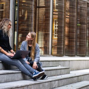 Duas mulheres conversando sentadas na escada