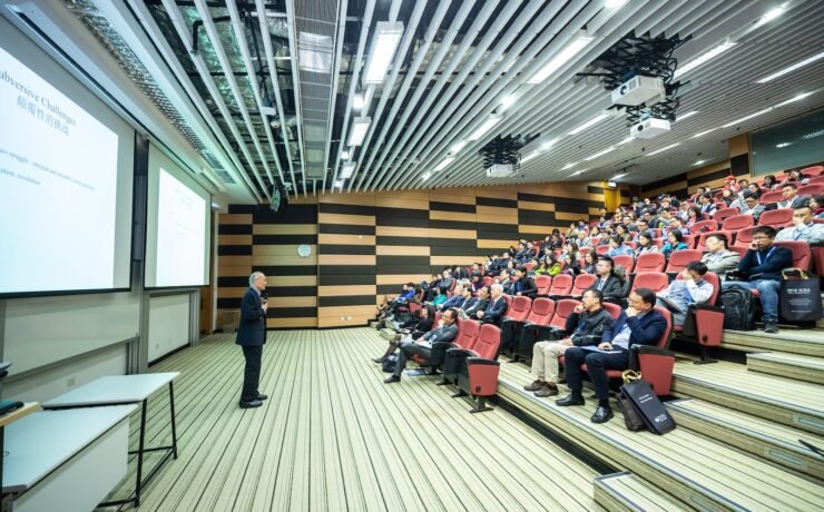 Uomo in aula che spiega davanti ad una platea di studenti