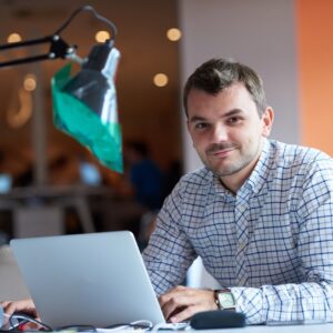 empresário no computador, sorrindo com confiança