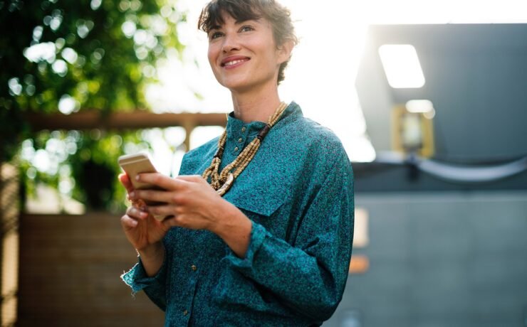 Fille souriante, téléphone portable à la main