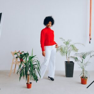 Mulher negra sorridente fazendo uma sessão de fotos com plantas