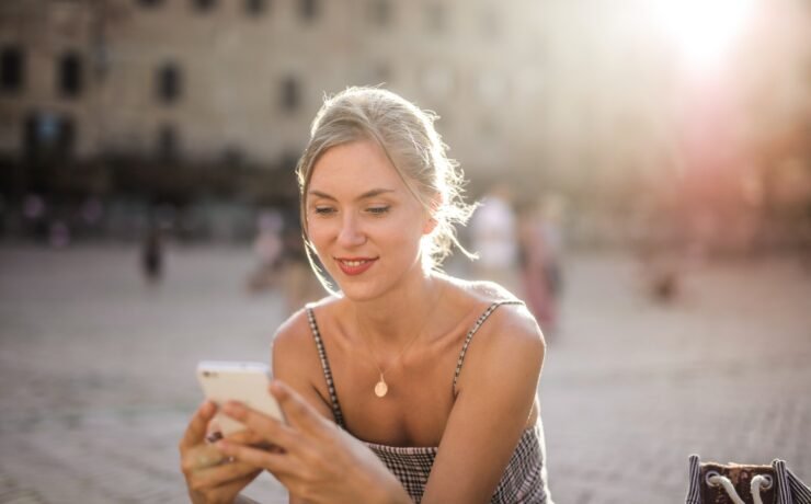 Fille en été envoyant un texto en souriant