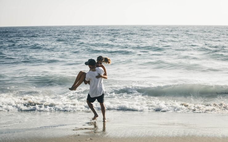 Homem carregando uma mulher na praia