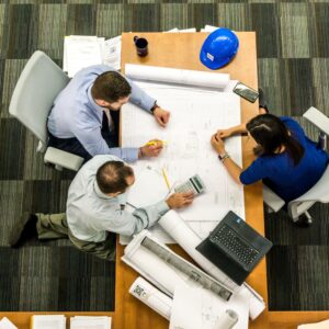 três pessoas sentadas em uma mesa no escritório