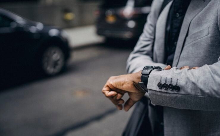 uomo in strada in città che guarda l'ora. Orologio, puntualità