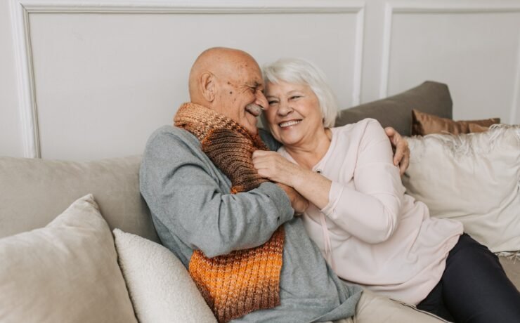 Couple mûr sur le canapé se serrant dans les bras