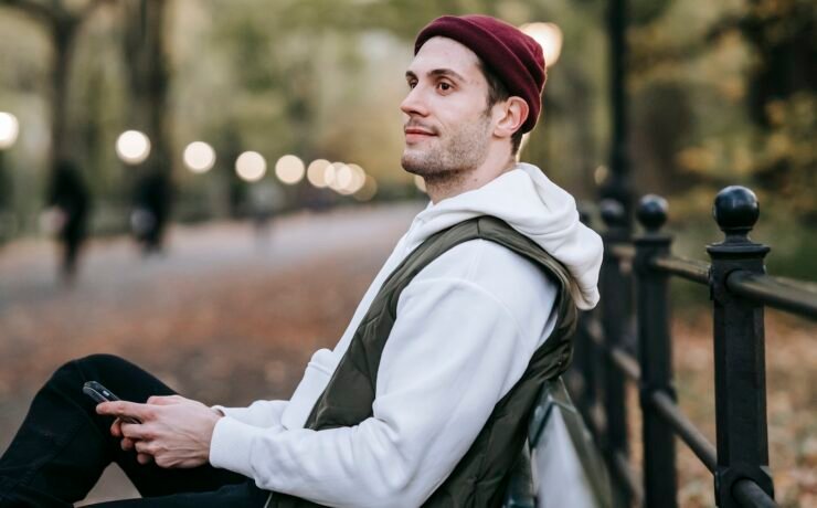 Homme regardant assis sur un banc de parc