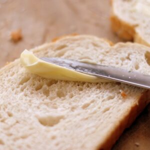 fatia de pão, faca passando margarina