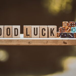 pequenos cubos de madeira contendo letras que formam as palavras GOOD LUCK e colocados ao lado de dados