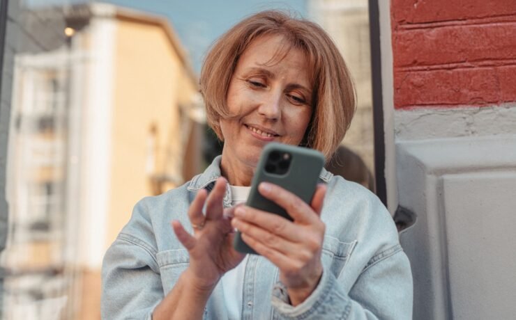 Woman smiling while looking at cell phone