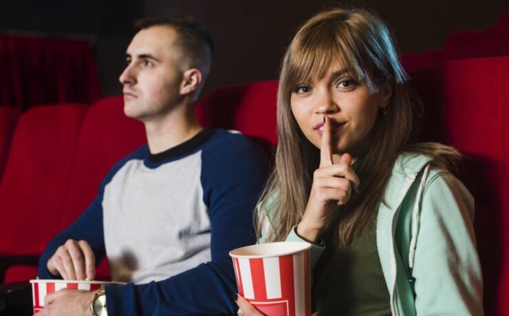 Girl shushes silence in the cinema with a boy