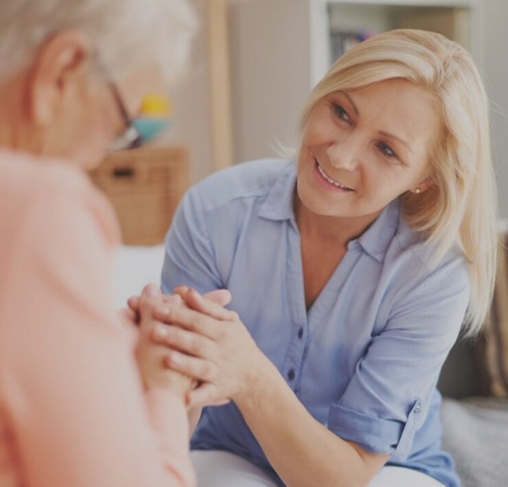 woman holding hands and smiling to other