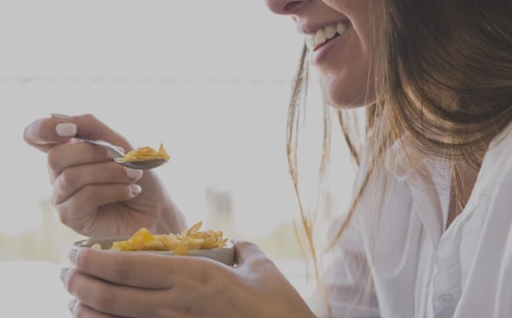 mulher comendo carvalhos café da manhã enquanto sorria