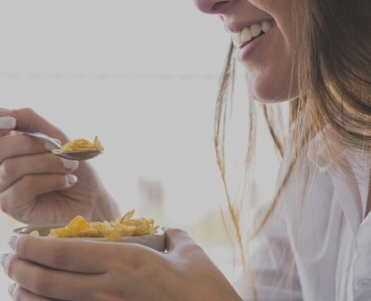 woman eating oaks breakfast while smiling