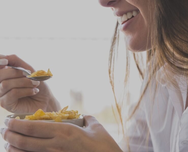 mulher comendo carvalhos café da manhã enquanto sorria