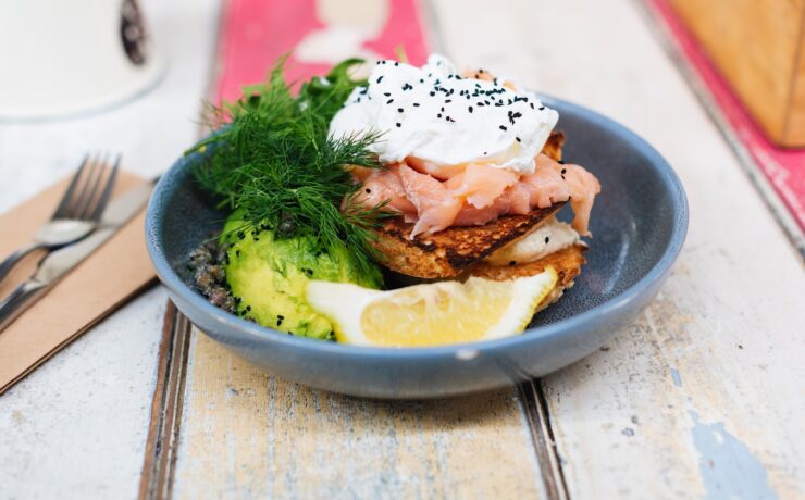 piatto con avocado, uova, salmone, verdure a foglia verde