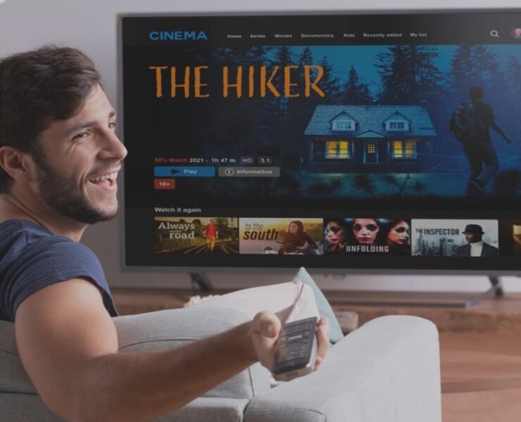 man looking at the television sit on a couch with popcorns
