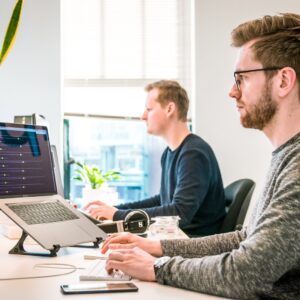 dois homens trabalhando em frente a computadores