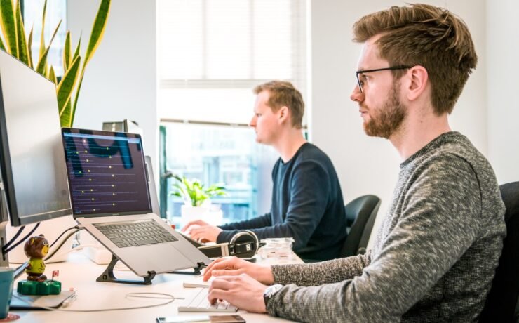 dois homens trabalhando em frente a computadores