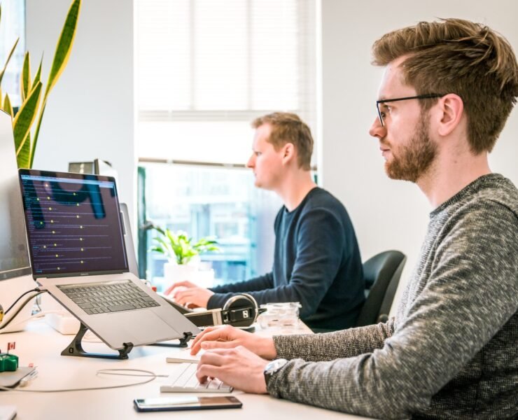 dois homens trabalhando em frente a computadores