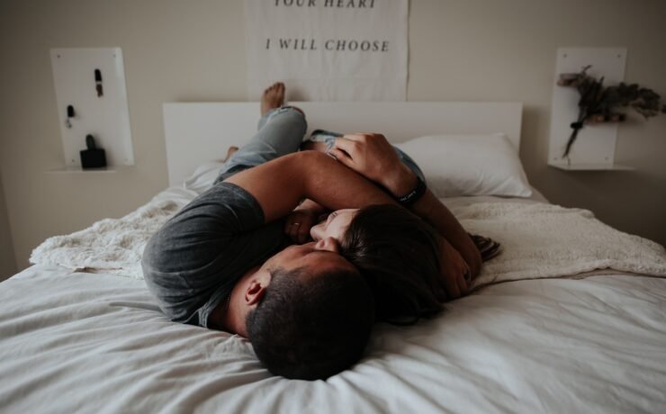 man and woman hugging each other and lying in bed