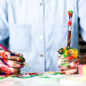 Pessoa pintando com as mão cheias de tinta