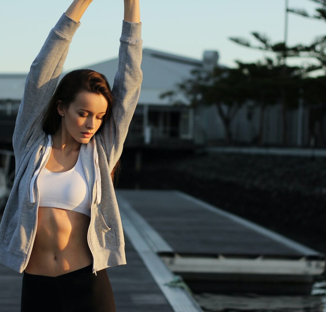 donna in abiti da palestra che si estende all'aperto