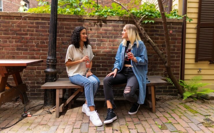 two seated women talking on a bench