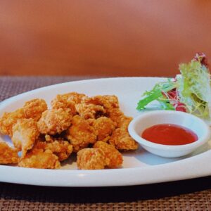 frango frito em travessa branca, molho, salada