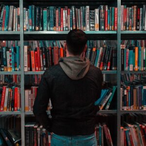 rapaz escolhendo um livro em uma livraria