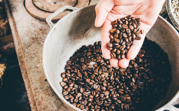 mano che tiene i chicchi di caffè