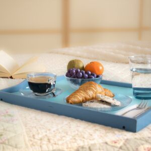 bandeja azul sobre uma mesa com croissant, café, copo de água