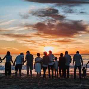 pessoas juntas na praia ao pôr do sol